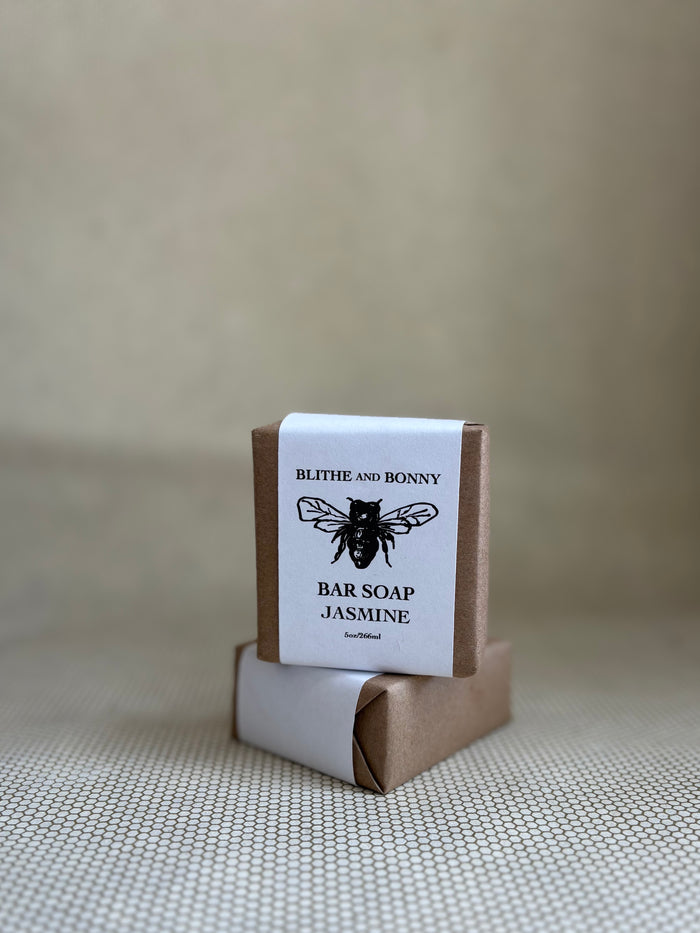 Bar of soap with a brown and white paper label cigar wrap. bumblebee graphic. vegan soap blithe and bonny.