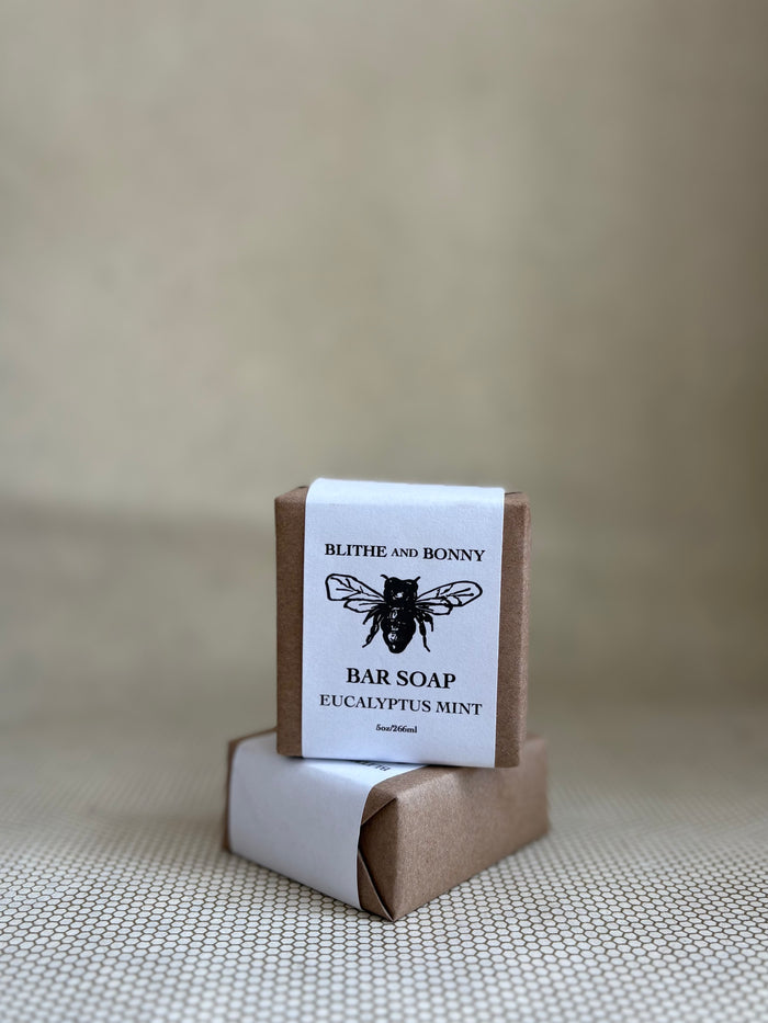 Bar of soap with a brown and white paper label cigar wrap. bumblebee graphic. vegan soap blithe and bonny.