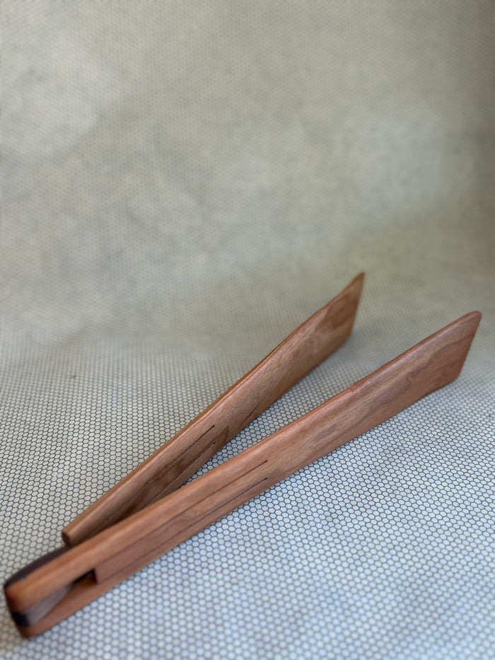 wooden serving tongs on light neutral background. Jonathan's Spoons.