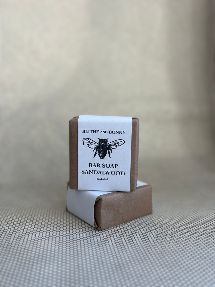 Bar of soap with a brown and white paper label cigar wrap. bumblebee graphic. vegan soap blithe and bonny.