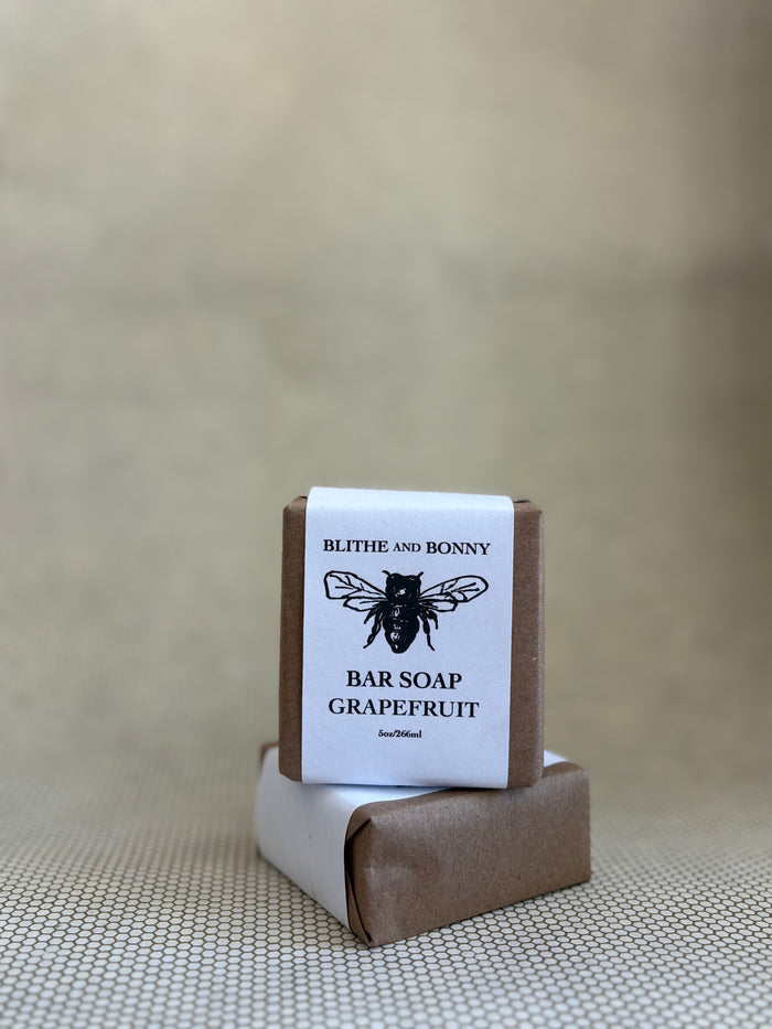 Bar of soap with a brown and white paper label cigar wrap. bumblebee graphic. vegan soap blithe and bonny.