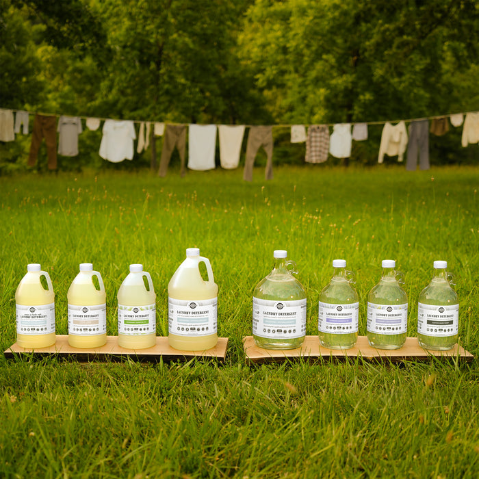 A collection of Rustic Strength Laundry Detergents lined up on the grass