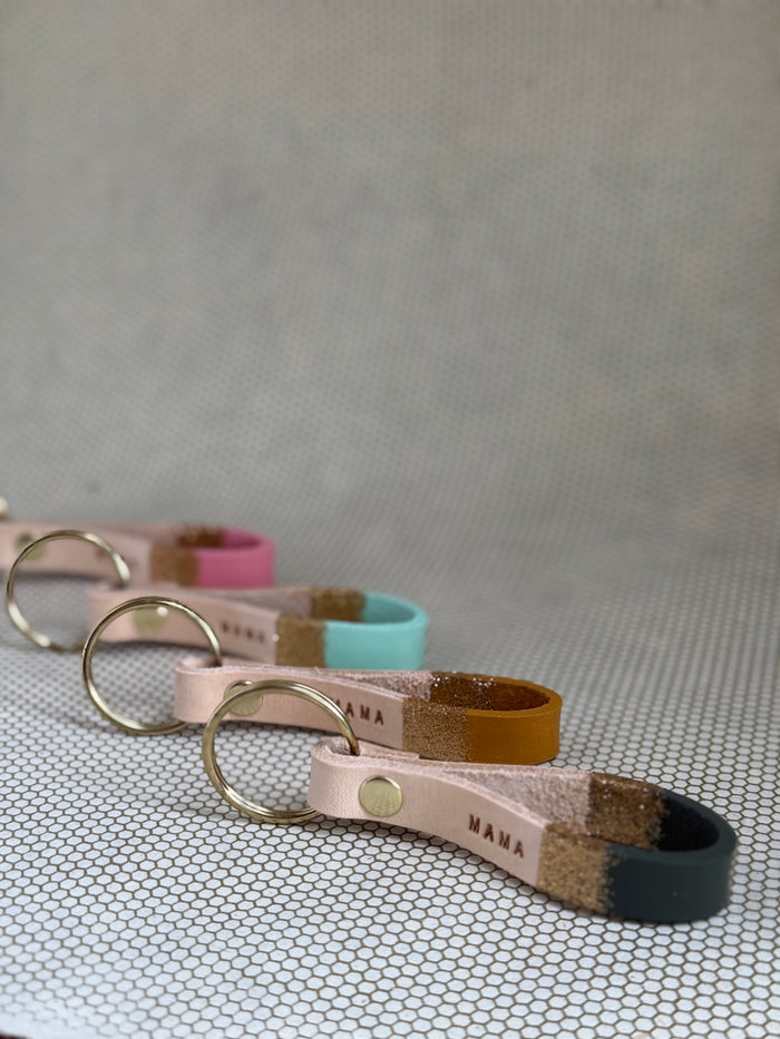 Set of varying color keychains with leather straps and "mama" lettering on leather.