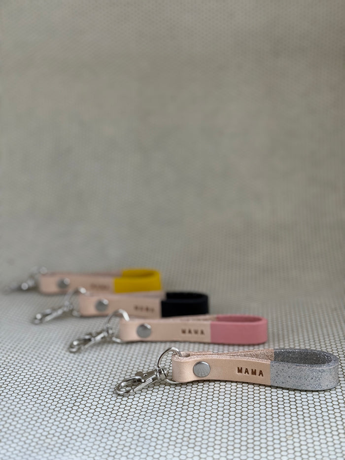 Set of varying color keychains with leather straps and "mama" lettering on leather.