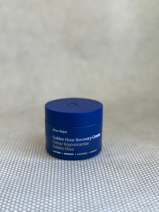 Blue jar of Ursa Major Golden Hour Recovery Cream on neutral background.