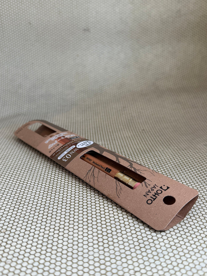 large wooden mechanical pencil with eraser on neutral background in cardboard packaging.